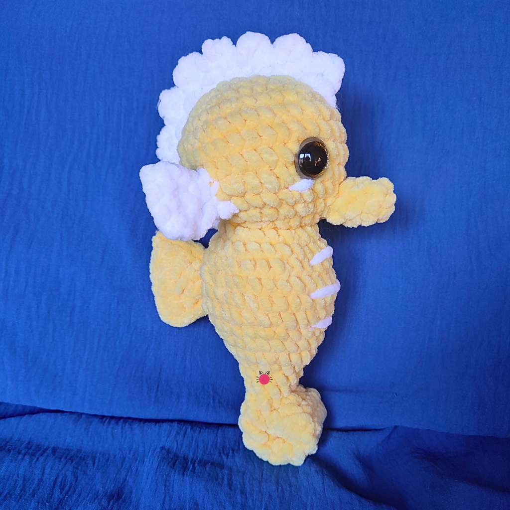 Crocheted seahorse toy on a blue background