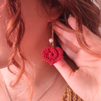 handmade crochet heart earrings on pink background
