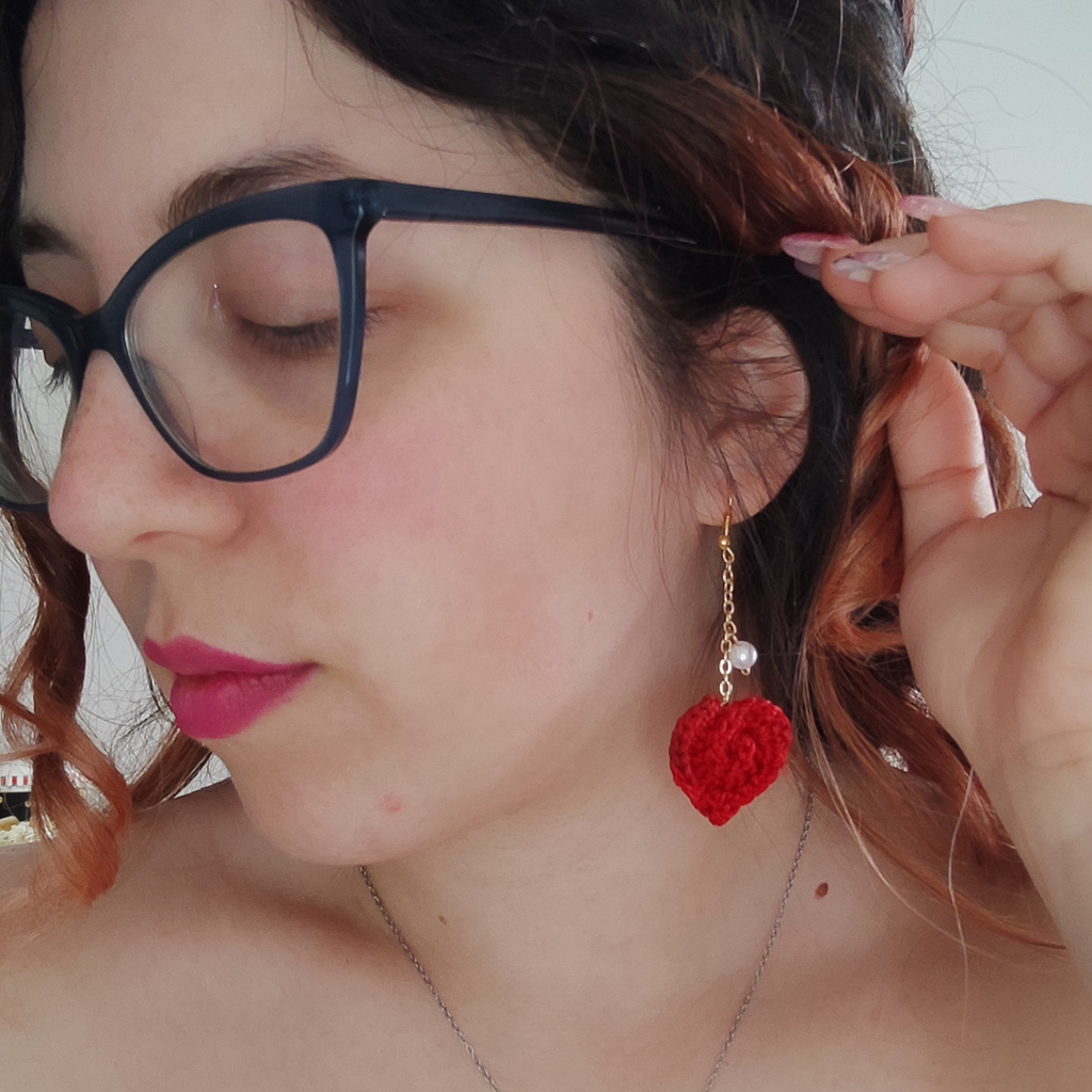 handmade crochet heart earrings on pink background