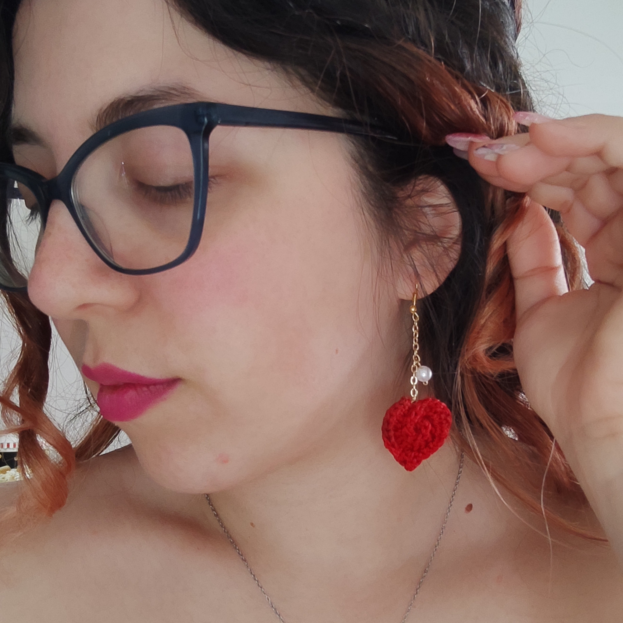 handmade crochet heart earrings on pink background